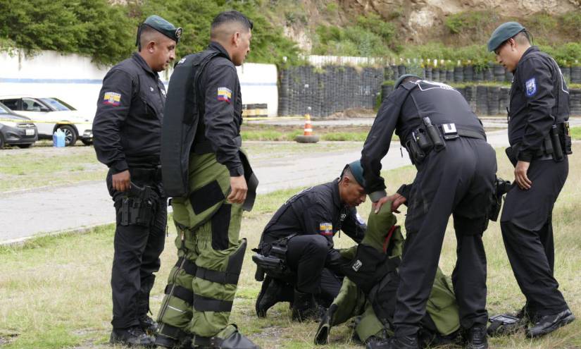 Policías se colocan trajes antiexplosivos donados por EE.UU. para llevar a cabo detonaciones controladas.