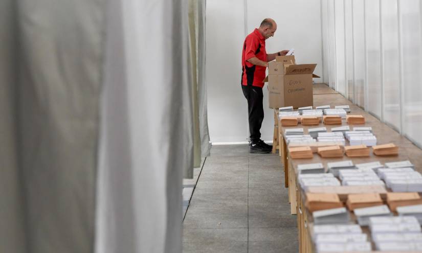 Operarios acaban de colocar y organizar este sábado, el material para el funcionamiento del colegio electoral en Pola de Siero, Asturias.