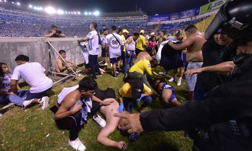AME443. SAN SALVADOR (EL SALVADOR), 20/05/2023.- Fanáticos auxilian a personas durante una estampida en el Estadio Cuscatláán previo a un partido de la Liga Mayor, hoy en San Salvador (El Salvador).