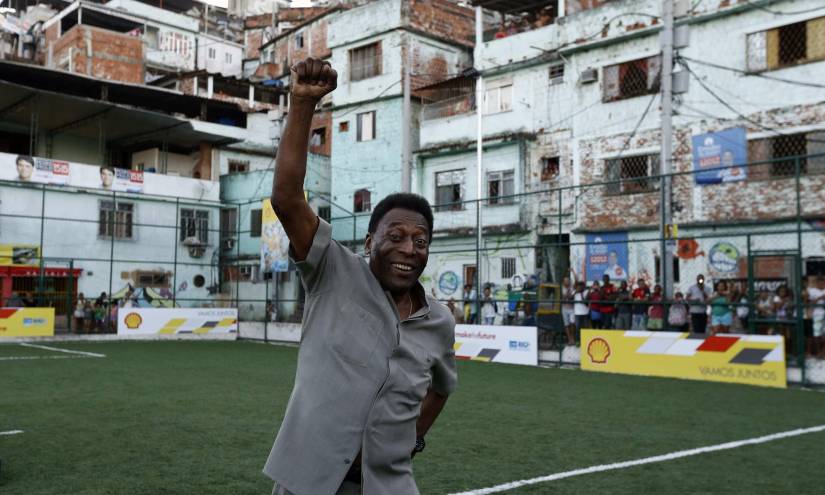 Pelé saluda a un grupo de aficionados en una cancha de Brasil.