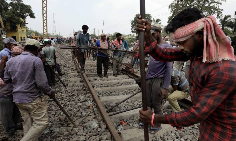 Personas trabajan en la reparación de la vía de ferrocarril.