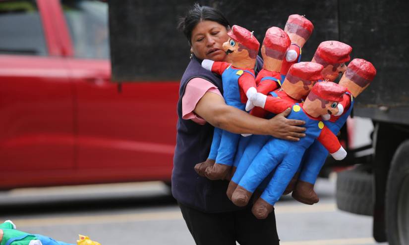 Una comerciante carga varios muñecos de Mario Bros.