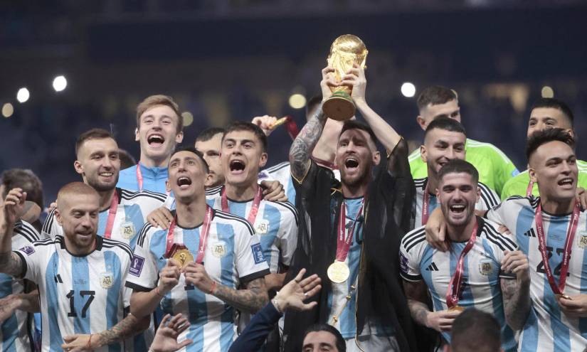 Lionel Messi (c) alza el trofeo de campeón del mundo, junto a los jugadores de la selección argentina, tras derrotar a Francia en la final de Qatar 2022.