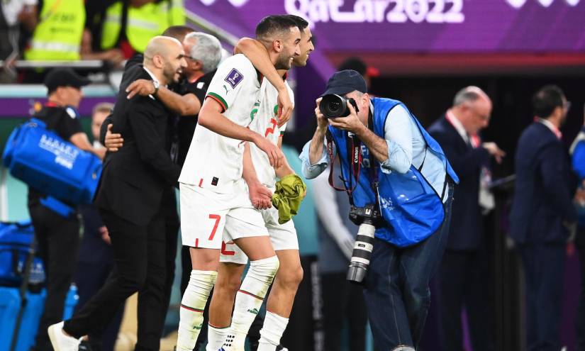 Jugadores y cuerpo técnico de Marruecos celebran el haber logrado el primer puesto en su grupo en Qatar 2022.