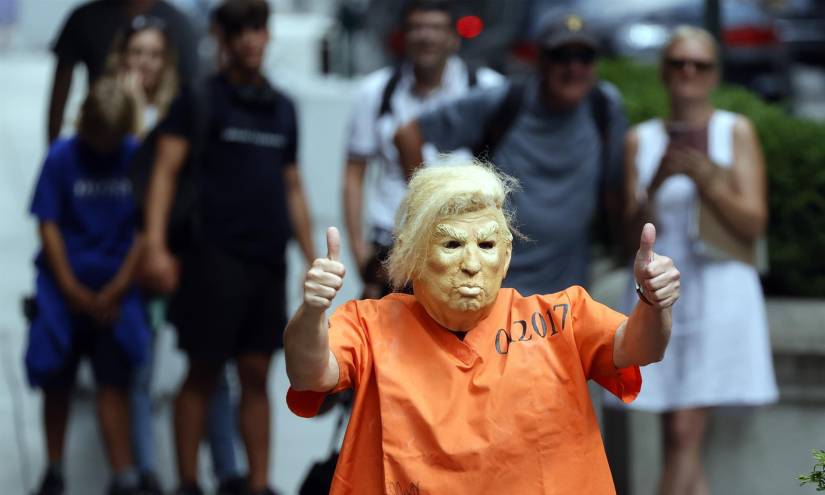 Un hombre se puso una máscara del exMandatario y una camiseta naranja.