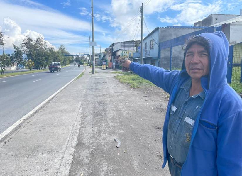 Ernesto Quille muestra el puente peatonal junto parterre con varias cruces.
