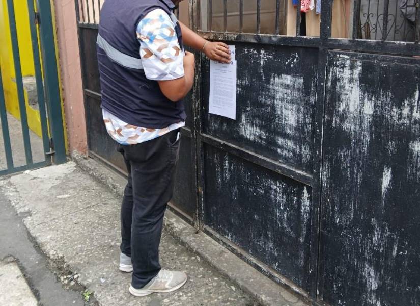 Imagen de funcionario municipal dejando una notificación en la vivienda donde está el carro implicado en el atropellamiento de un perro en el norte de Guayaquil.