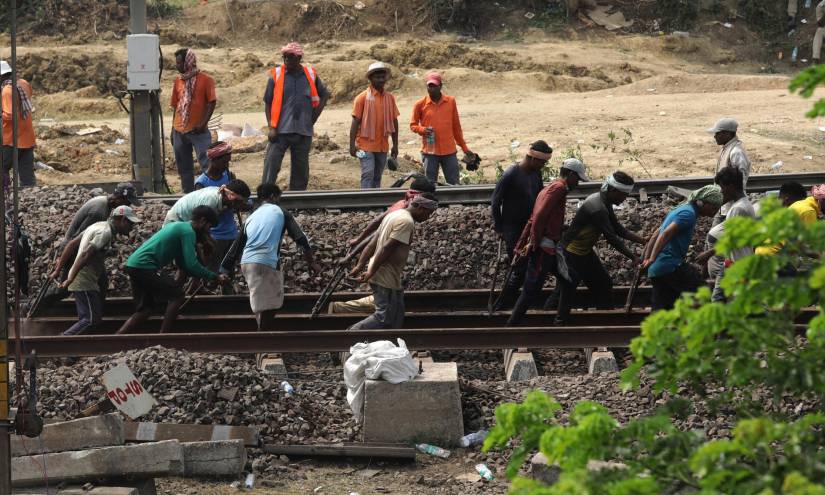 Personas trabajan en la reparación de la vía de ferrocarril.