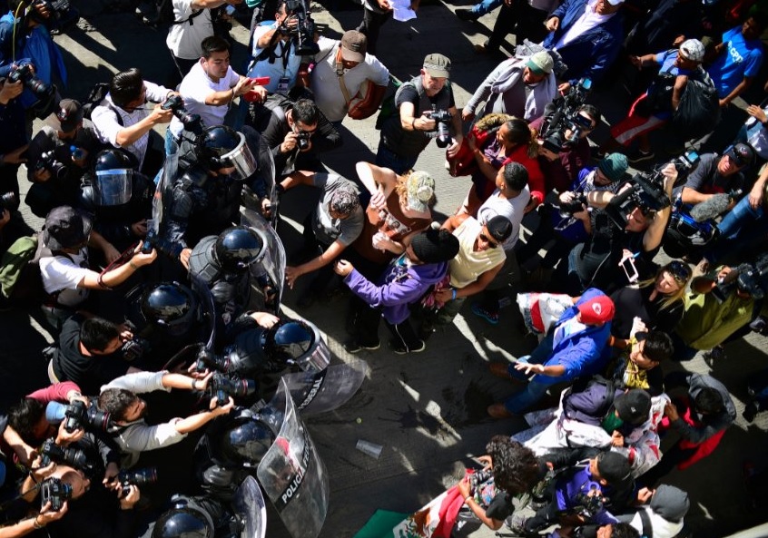 Migrantes tratan de saltar la valla fronteriza entre México y EEUU
