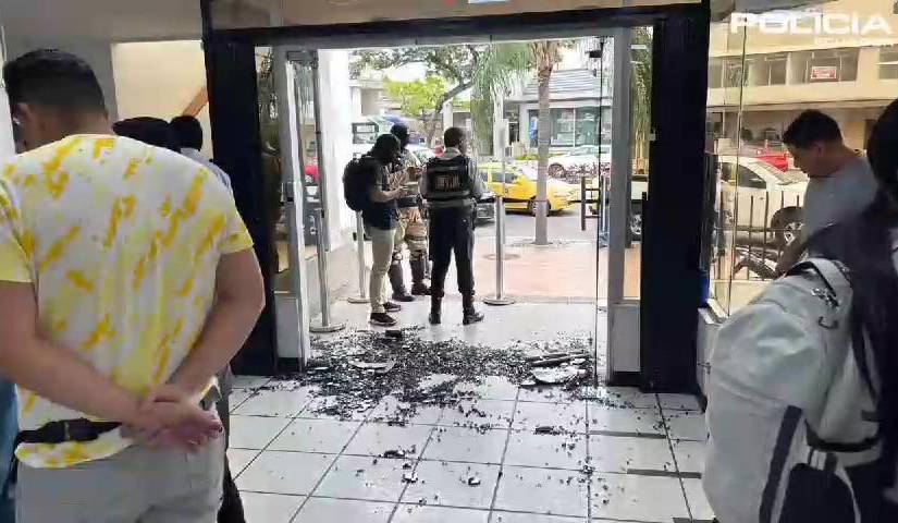 Imagen de cristales rotos en la entrada de una agencia bancaria, tras balacera entre policías y sujetos, en el norte de Guayaquil.