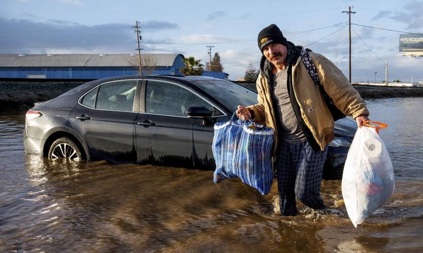 Jesús Torres saca pertenencias de su casa inundada por las lluvias en Merced, California.