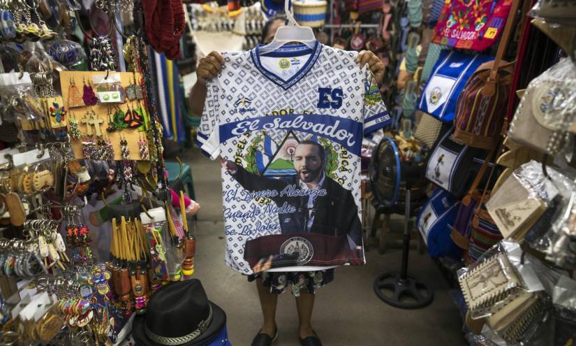 Una vendedora muestra una camiseta con la imagen del presidente Nayib Bukele, quien está librando una guerra abierta contra las pandillas en El Salvador.