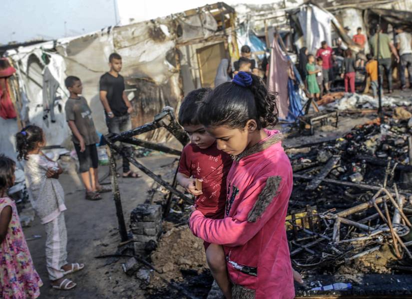 Palestinos inspeccionan tiendas de campaña improvisadas destruidas tras el bomnardeo