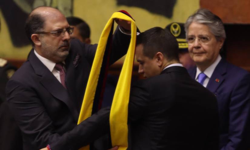 El presidente de la Asamblea Nacional, Henry Kronfle, coloca la banda presidencial a Daniel Noboa. Junto a ellos está el ahora expresidente Guillermo Lasso.