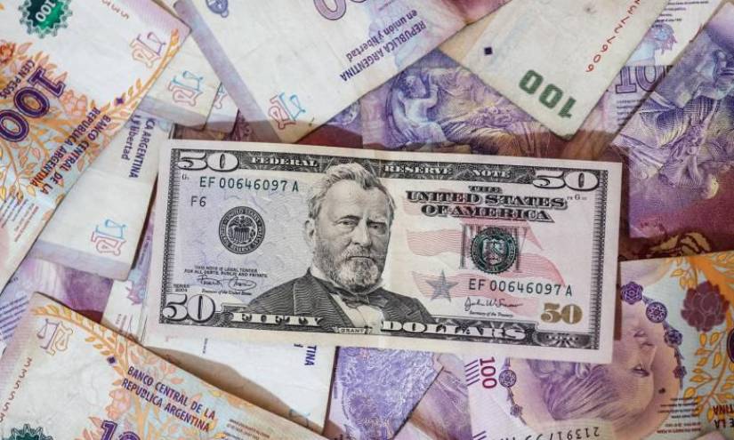 Fotografía de archivo de billetes de pesos argentinos y dólares estadounidenses.