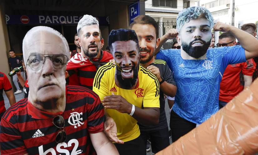 Aficionados de Flamengo posan con máscaras del entrenador Dorival Junior (i) y los jugadores Giorgian De Arrascaeta (2-i), Everton Ribeiro (2-d) y Gabriel Barbosa 'Gabi' (d) hoy, afuera de un hotel en el centro de la urbe.