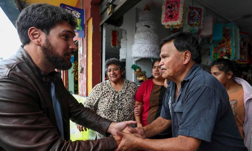 El candidato presidencial Jan Topic saluda a habitantes de un barrio durante un recorrido en Quito.