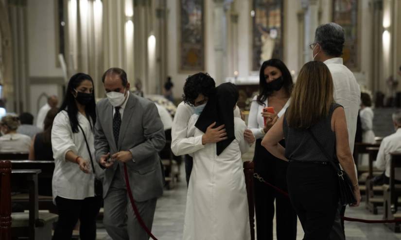 Tommy Hardeman (centro), hijo de Tania, abraza a una monja que acudió a la ceremonia religiosa.