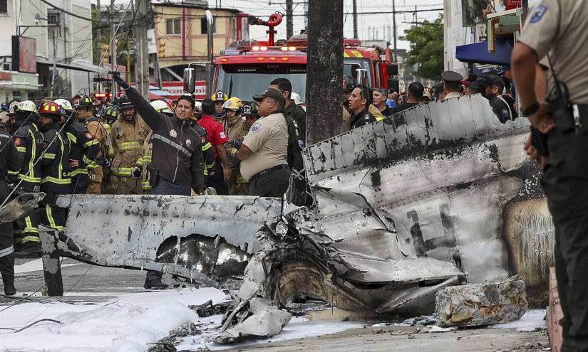 Bomberos, policías y funcionarios son vistos hoy en la zona del accidente de una avioneta en Guayaquil.