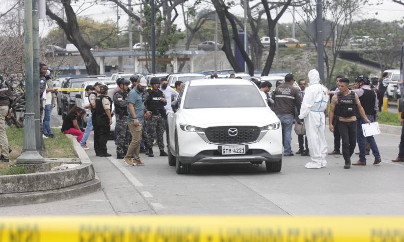 Policías inspeccionan el vehículo baleado en el que se transportaba el fiscal César Suárez.