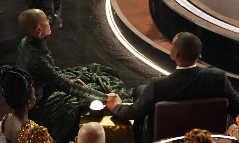 Jada Pinkett Smith, izquierda, y Will Smith se dan la mano en los Óscar, el 27 de marzo de 2022 en el Teatro Dolby en Los Ángeles.