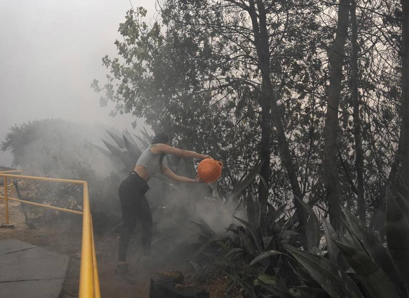 Una joven ayuda a extinguir un fuego de los incendios forestales que afectan la zona de Canal Beagle, Viña del Mar, Región de Valparaiso (Chile).