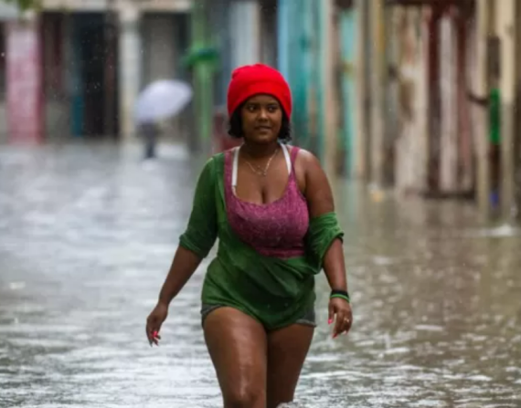 Una mujer caminando en medio de una inundación