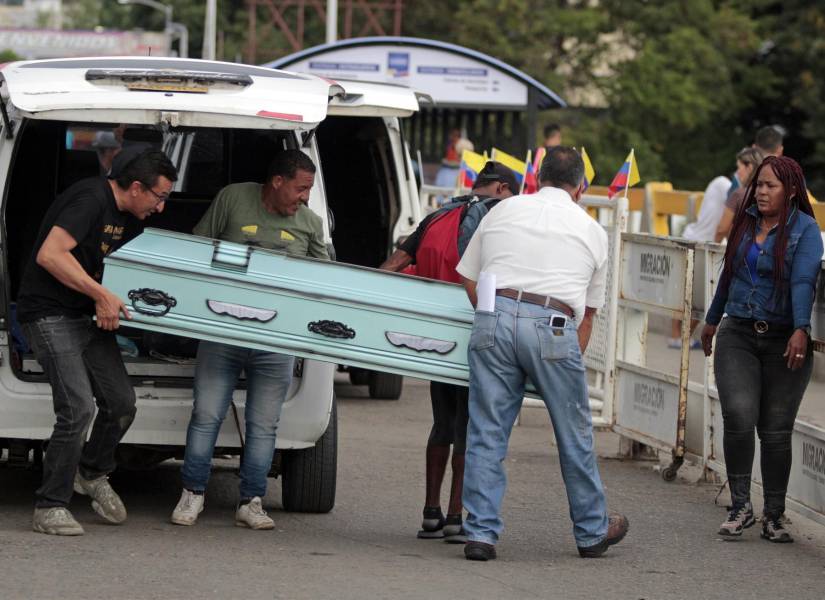 Personas cargan un féretro por el Puente Internacional Simón Bolívar.