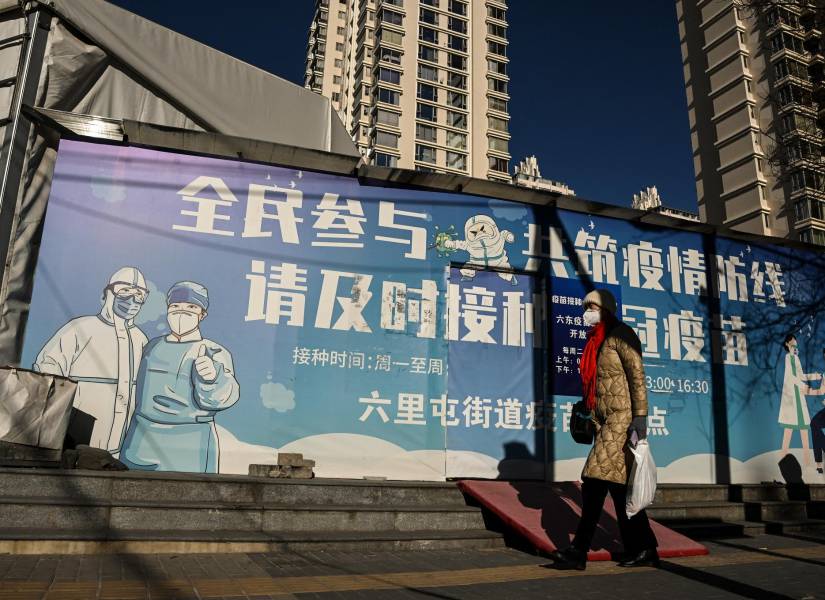 Una mujer con mascarilla camina por una calle de Pekín el 11 de diciembre de 2022 en medio de la pandemia de Covid-19.