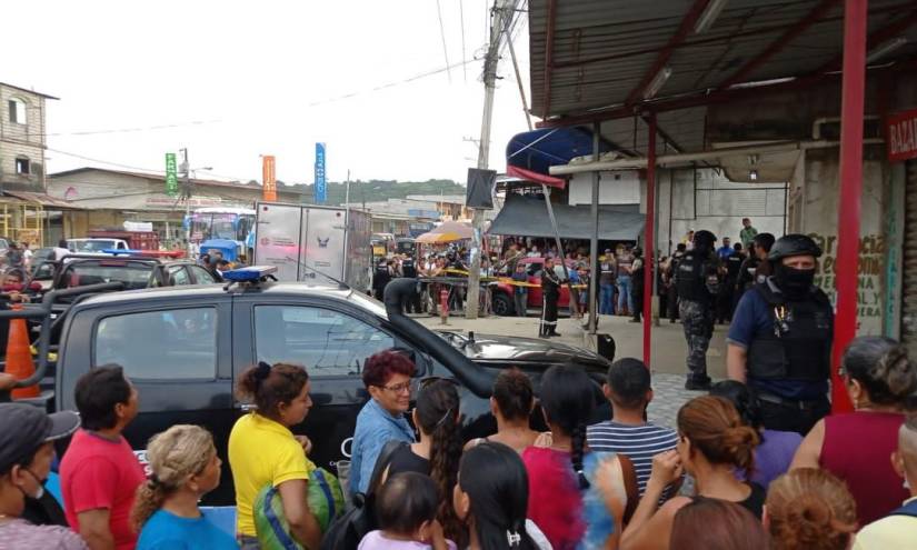 Moradores del sector La Ladrillera, en el noroeste de Guayaquil, rodean la escena del crimen, donde cuatro personas murieron.