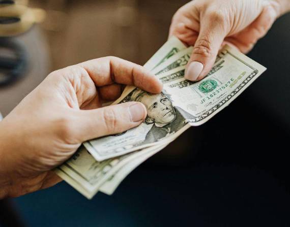 Persona entregando dinero a otra.