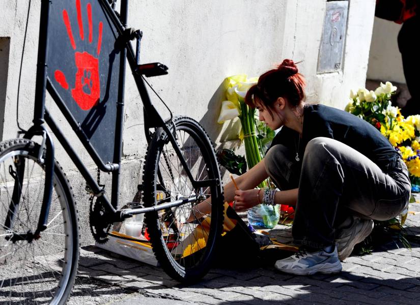 Una mujer enciende una vela en un monumento improvisado en memoria de un niño que falleció tras sufrir graves heridas en la tragedia de la estación de tren de Novi Sad en noviembre de 2024.