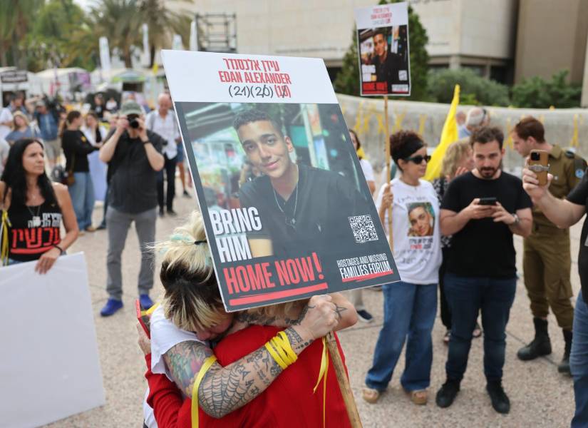 La gente reacciona mientras se reúne viendo una transmisión en vivo en una pantalla grande que informa sobre la liberación del soldado estadounidense.