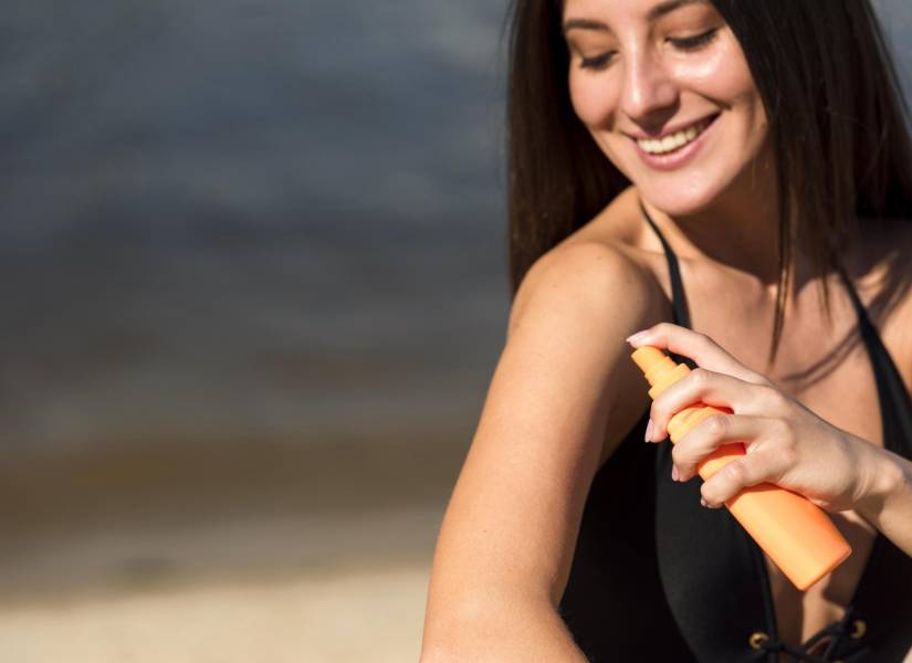 Mujer colocándose crema de protección solar