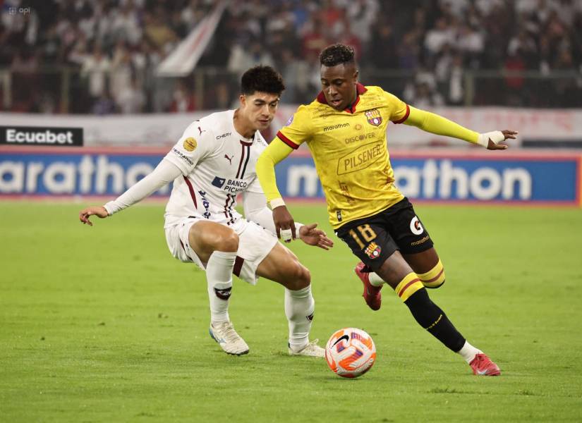 El volante de Liga de Quito, Gabriel Villamil, disputa el balón con el lateral de Barcelona SC, Bryan Carabalí