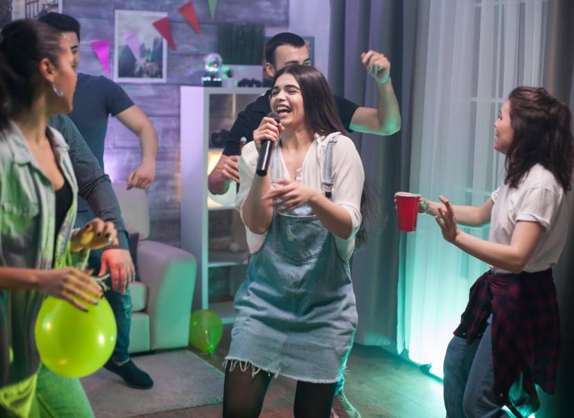Grupo de amigos cantando en una fiesta.