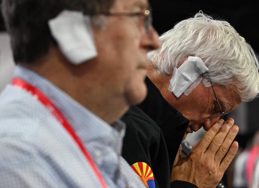 Un delegado republicano usa una gasa en su oreja, como la que Trump uso luego del atentado.