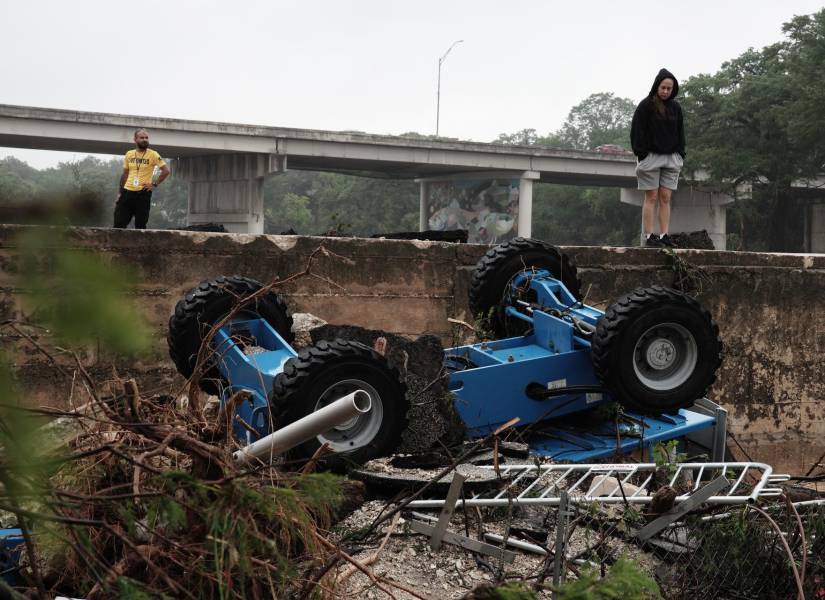 Personas observan una maquinaria de construcción entre los escombros dejados por las inundaciones en el río Guadalupe, en Kerrville, Texas, EE. UU.
