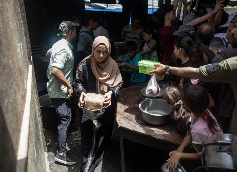 Refugiados en gaza esperando por comida en una cocina de caridad.