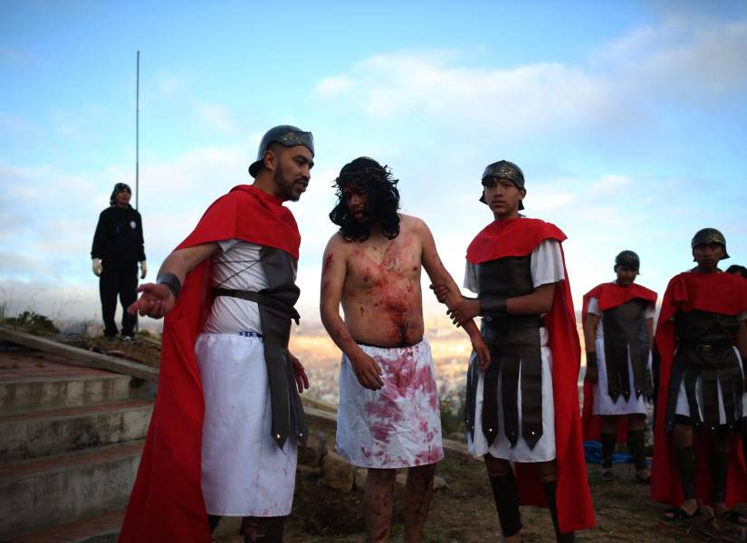 Personas representan el viacrucis en un recorrido de dos horas que conmemora la vida, la pasión y la muerte de Jesús este viernes, en La Paz (Bolivia).