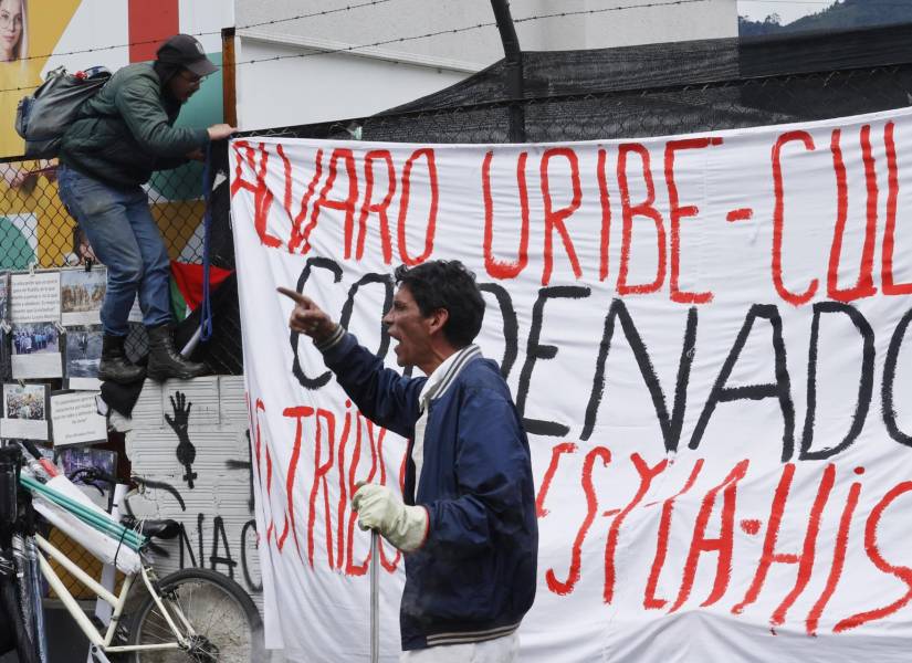 Una persona participa en un plantón contra el expresidente Álvaro Uribe este viernes, frente al Complejo Judicial de Paloquemao en Bogotá (Colombia).