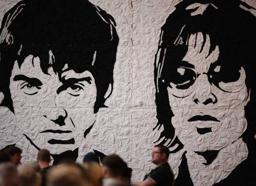 CARDIFF (United Kingdom), 04/07/2025.- Fans queue for a photograph with a mural of Oasis brothers Noel and Liam Gallagher made by artist Nathan Wyburn from 3000 bucket hats ahead of the first gig of the Oasis Live 25 tour in Cardiff, Britain, 04 July 2025. Oasis begin their sold out 41-date reunion tour in Cardiff, marking the first time that brothers Noel and Liam Gallagher have played together since 2009. (Reino Unido) EFE/EPA/ADAM VAUGHAN