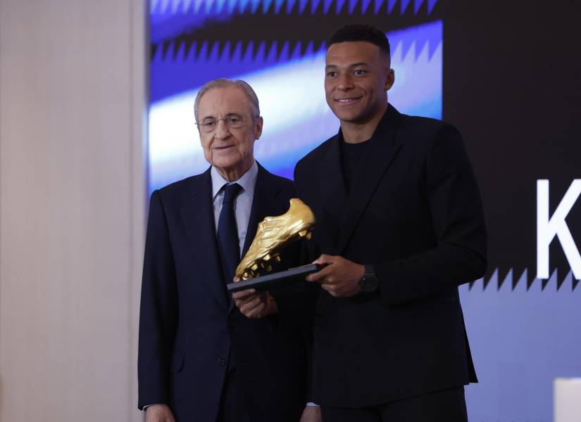 El delantero francés del Real Madrid, Kylian Mbappé (d) posa junto al presidente del club, Florentino Pérez, tras recibir este viernes la Bota de Oro en un acto celebrado en el palco del Santiago Bernabéu.