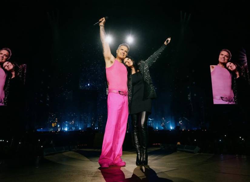 Robbie Williams y Laura Pausini en un concierto.
