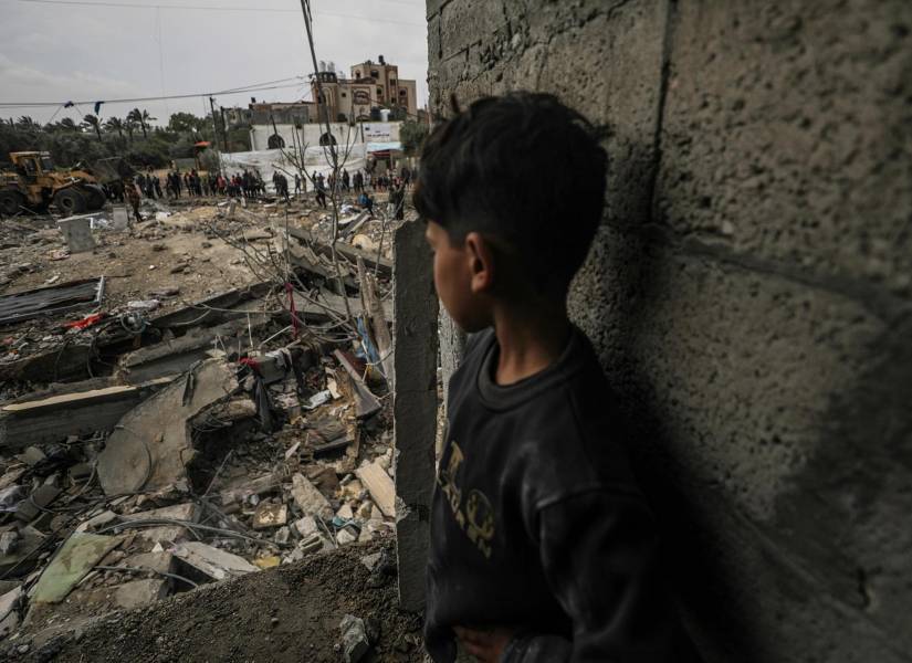 Un niño observa cómo los palestinos buscan a personas desaparecidas bajo los escombros de una casa destruida en el campo de refugiados de Al Nusairat, al sur de Gaza Franja, 19 de marzo de 2024.