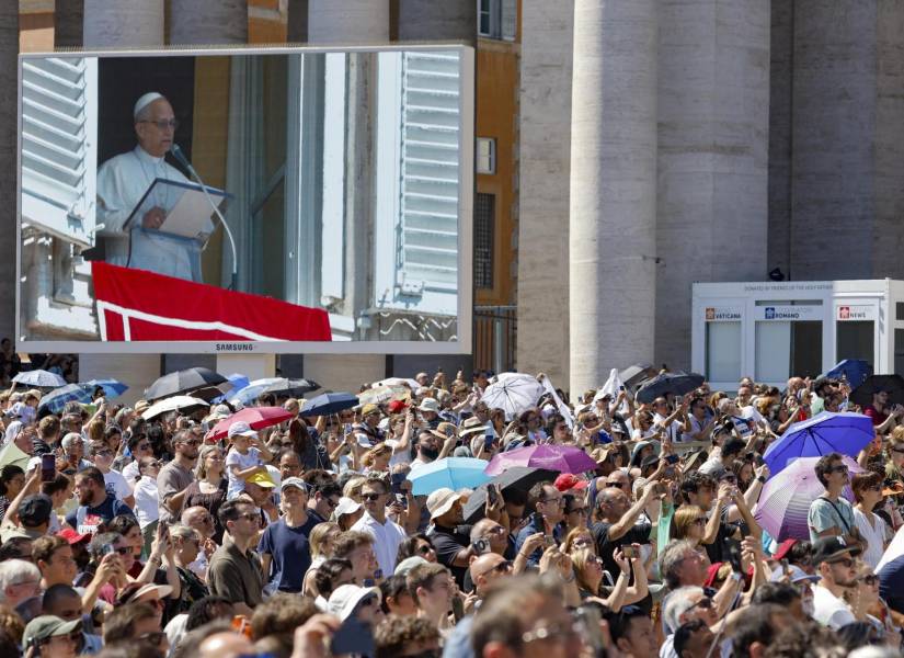 El papa León XIV en una pantalla mientras dirige la oración del Ángelus desde una ventana con vistas a la Plaza de San Pedro.