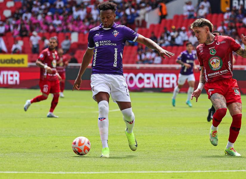 El delantero de Liga de Quito, Michael Estrada, conduce el balón ante la marca de Bryan Bentaberry, defensa de Mushuc Runa