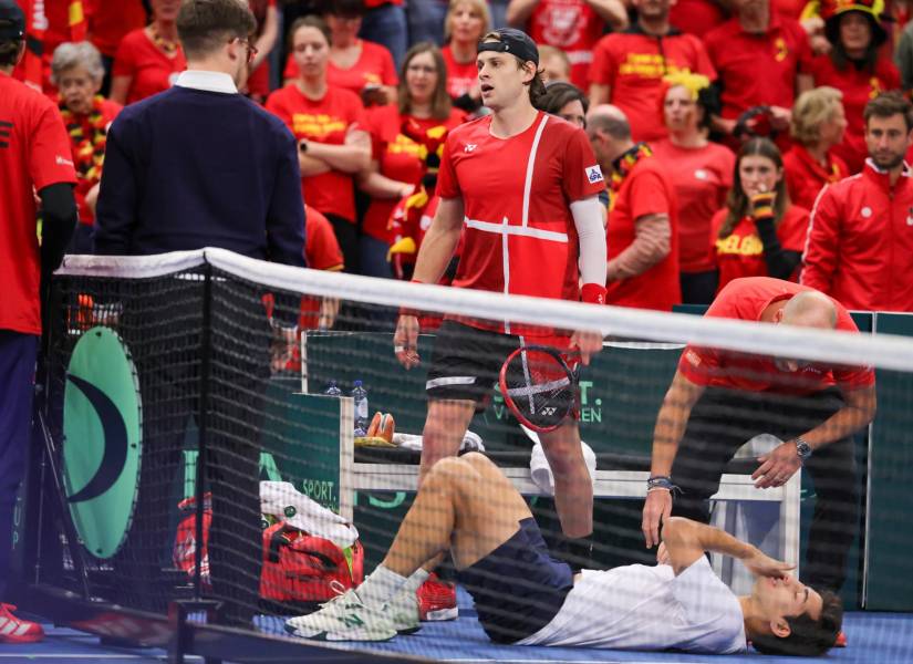 El tenista chileno Cristian Garin con signos de dolor sobre la pista durante el partido de la Copa Davis jugado en Bruselas, Bélgica.