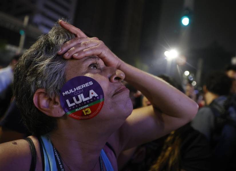 Simpatizantes del expresidente y candidato presidencial, Luiz Inácio Lula da Silva, observan cómo avanzan los resultados, en una plaza de Sao Paulo.