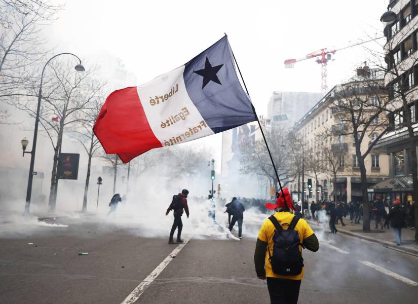 Un manifestante cargando una bandera de Francia.